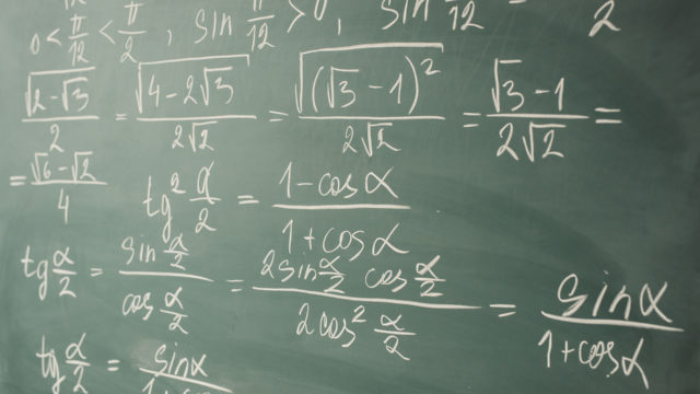 Algebra, mathematics. Trigonometry and elementary functions written on the chalkboard.